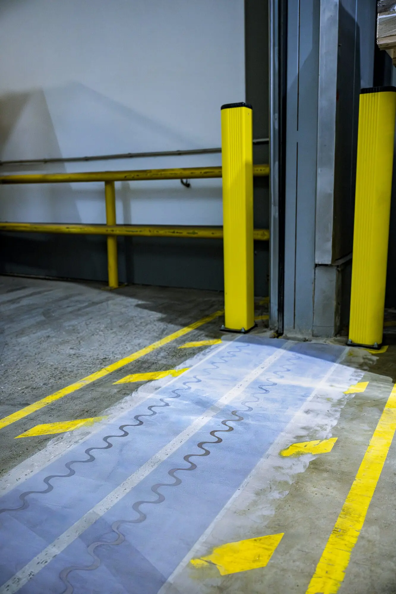 Doppelpaneel mit zwei sinusförmigen Fugen im Fahrweg vor einem Hallentor bei POLI-TAPE